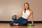 Woman sitting on a yoga mat with exercise balls in a home setting
